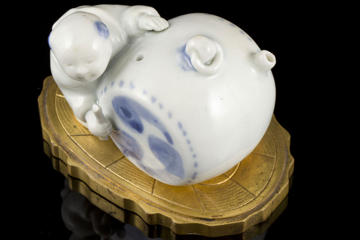 A Japanese blue and white ihirado figure of a young-boy-and-drum-shaped water dropper mounted on a European gilt bronze base 